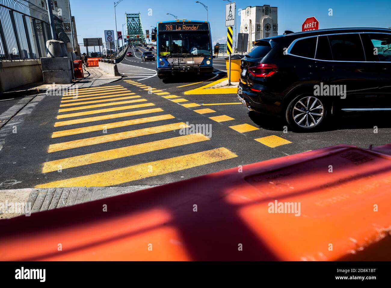 A city bus turning at a zebra crossing (crosswalk) on the Jacques