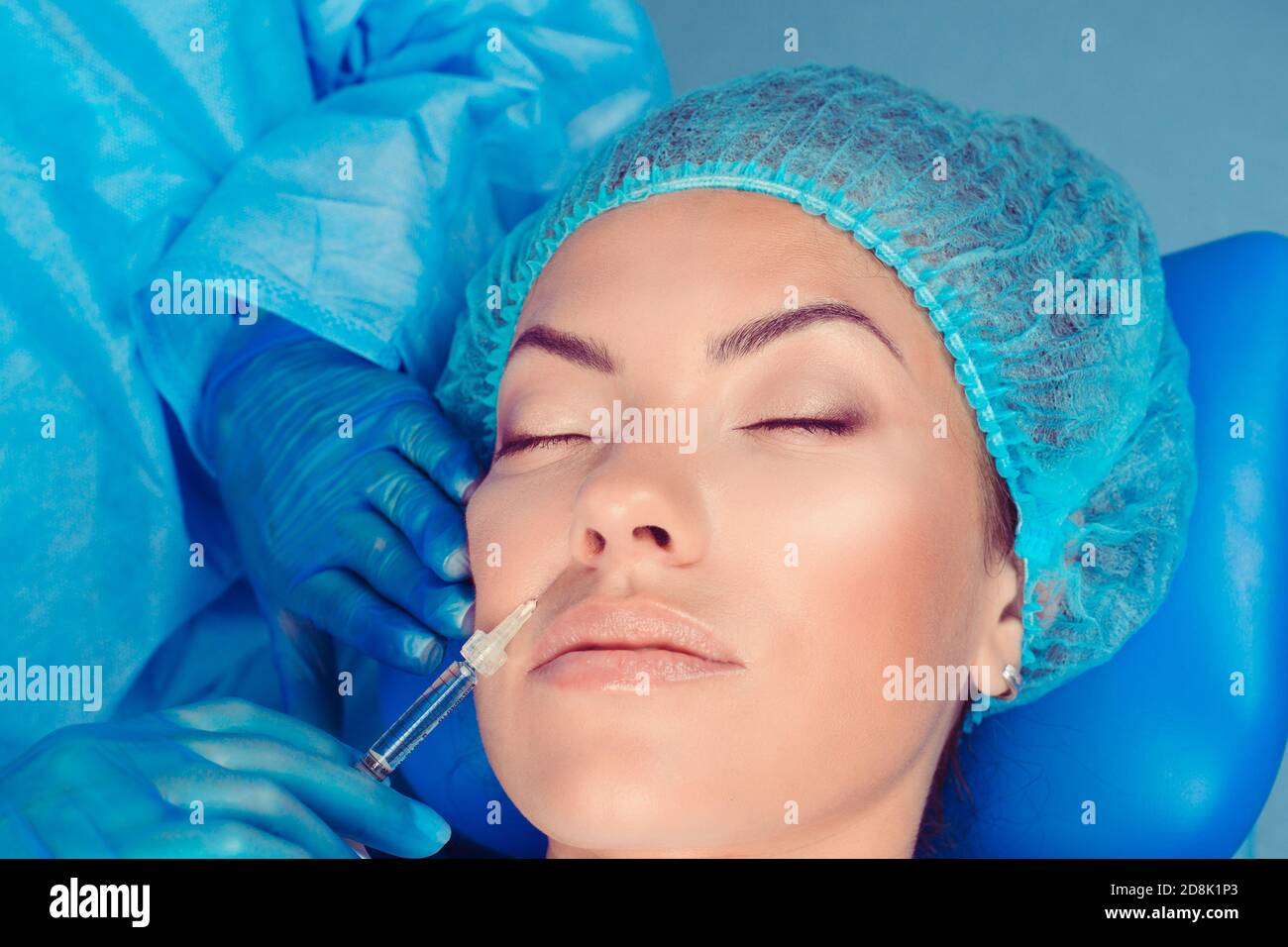 Hyaluronic acid injection for facial rejuvenation procedure in nasolabial fold wrinkle. Patient receiving cosmetic therapy in a clinic surgery room; O Stock Photo