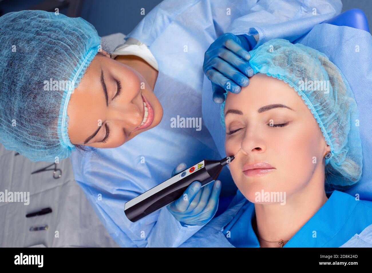 Woman having a non surgical procedure to remove nasolabial wrinkles with a laser device by a cosmetologist in a medical clinic. Thread lift procedure. Stock Photo