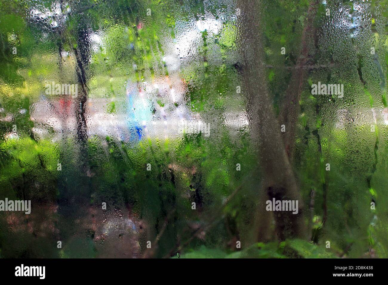 A window with condensation blurs the outside world. Stock Photo