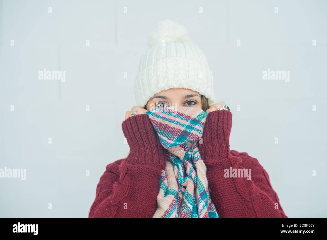 Closeup shot of a girl with her face wrapped up in a scarf on white background Stock Photo
