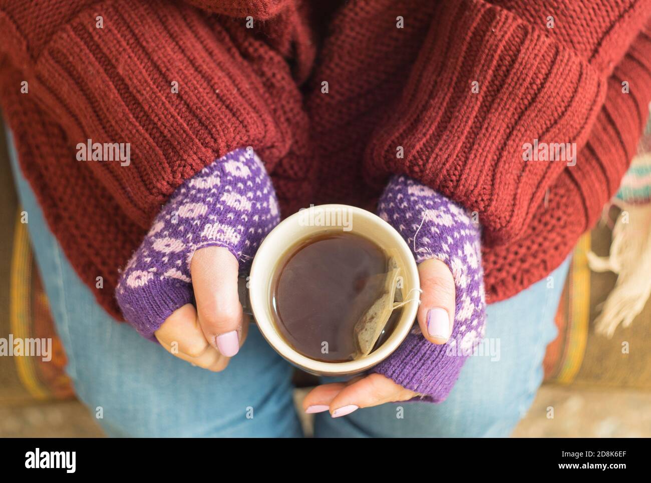 Top view of girls hands holding a mug with tea Stock Photo