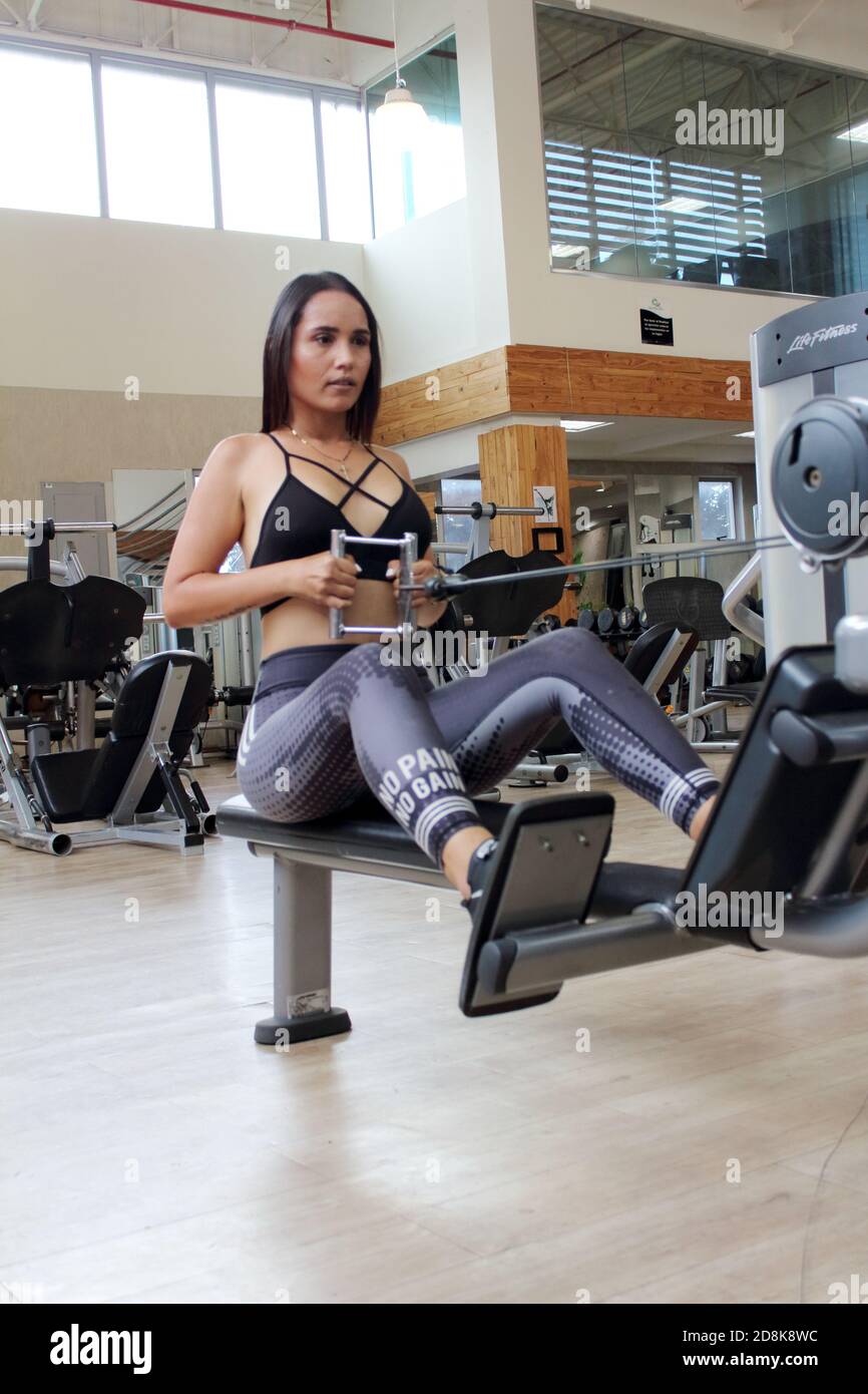 girl training in in gym using different machines cardio training