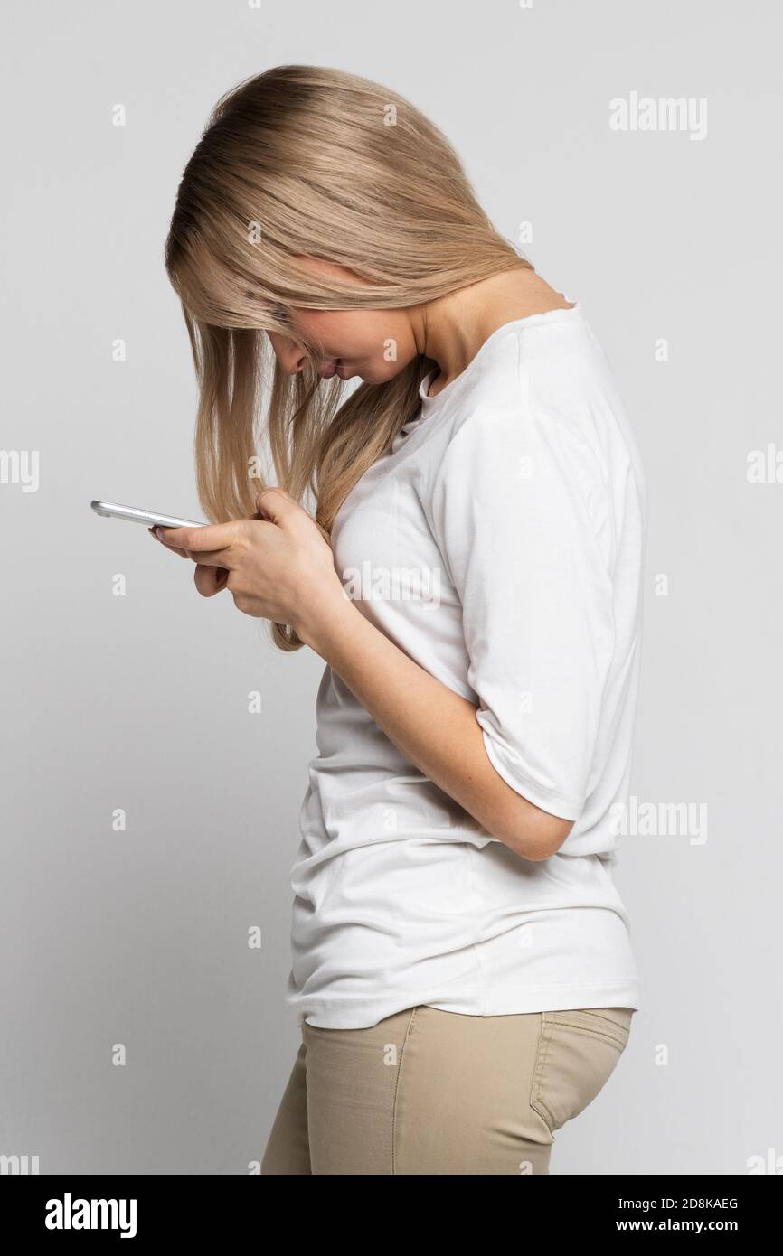 Caucasian female using mobile phone with scoliosis, side view. Rachiocampsis, kyphosis curvature of the spine, Incorrect posture, scoliosis, orthopedi Stock Photo