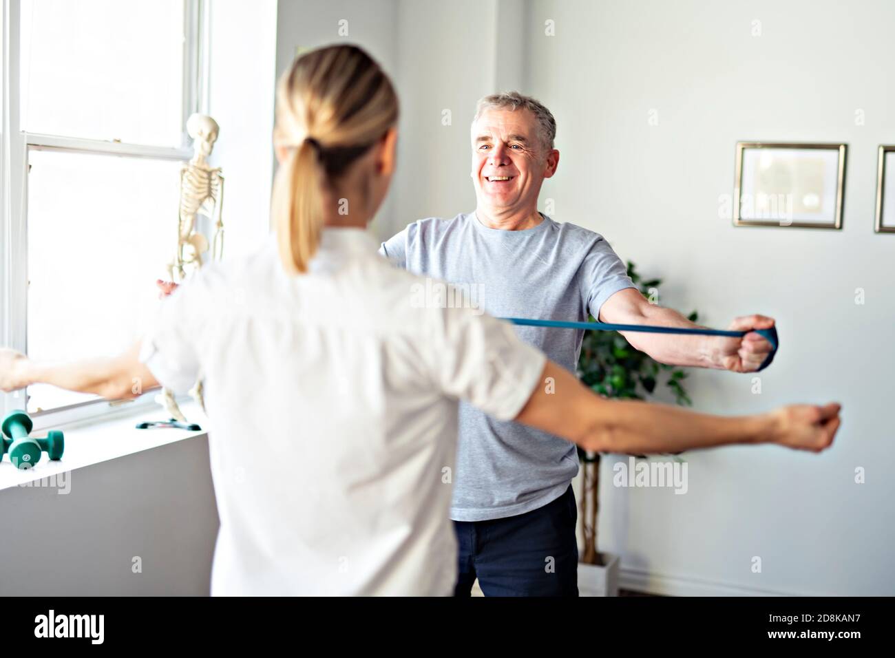 A Modern rehabilitation physiotherapy worker with senior client Stock ...