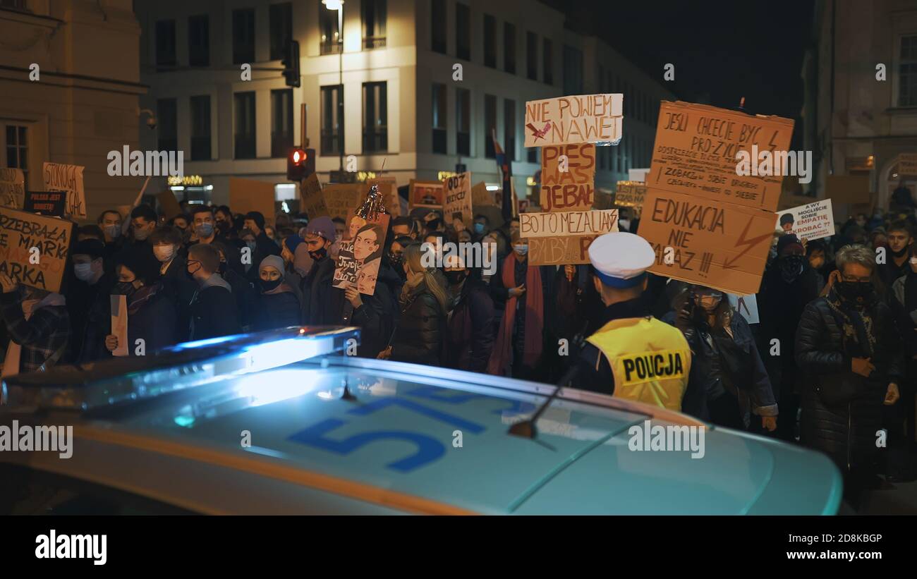 Warsaw, Poland 30.10.2020 - Anti abortion and human rights protest, Womens strike, demonstrants passing near police car illuminated by emergency light. High quality photo Stock Photo