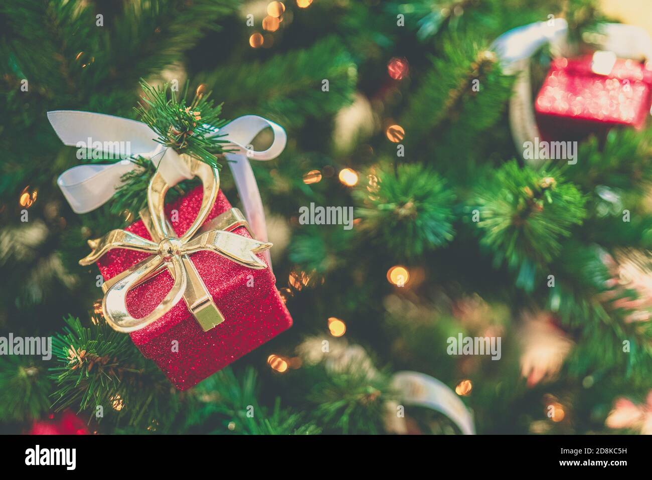 Christmas fir tree with decorations, mini lights and a red gift box ...