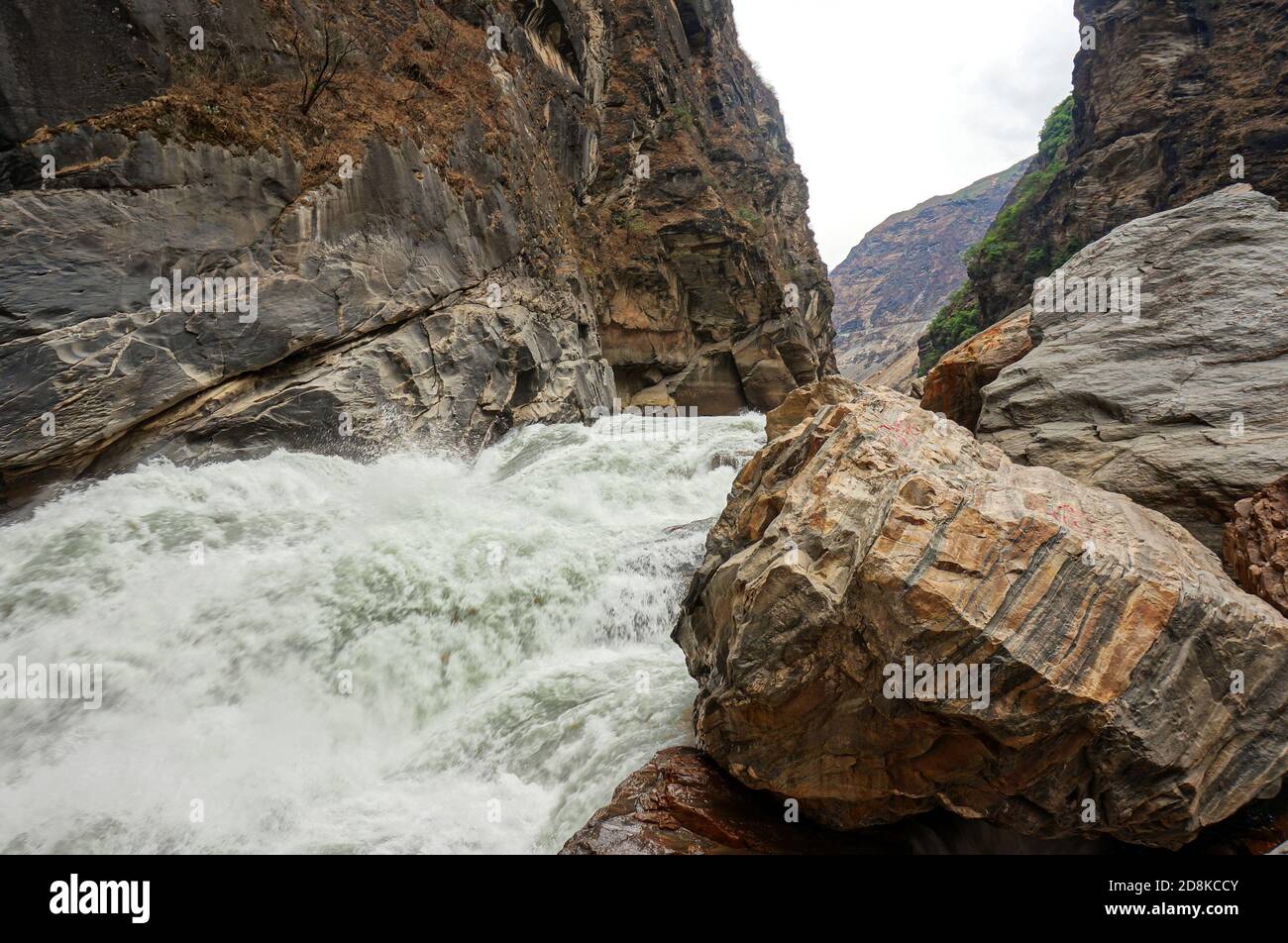 Wild river in the brown mountains. Stripy rock on the front Stock Photo