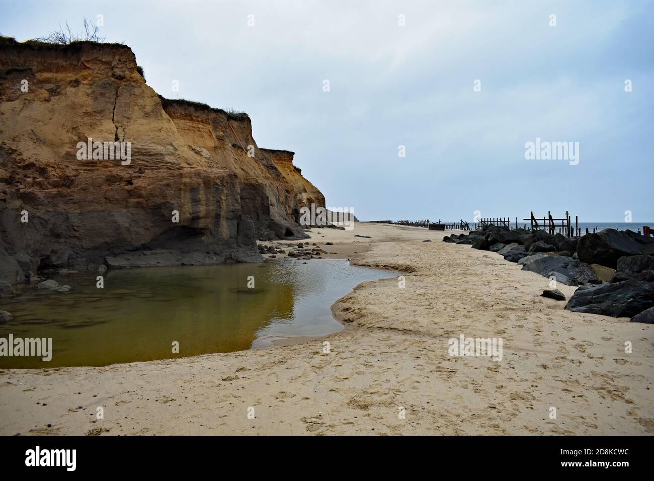 The cliffs at Happisburgh Beach displaying costal erosion, Norfolk, UK.  Large boulders have been placed along to beach to slow down further damage. Stock Photo