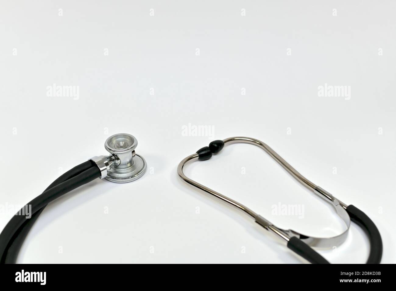 Acoustic head with binaural tubes and headband on the left and ear tips on the right medical stethoscope. Stock Photo