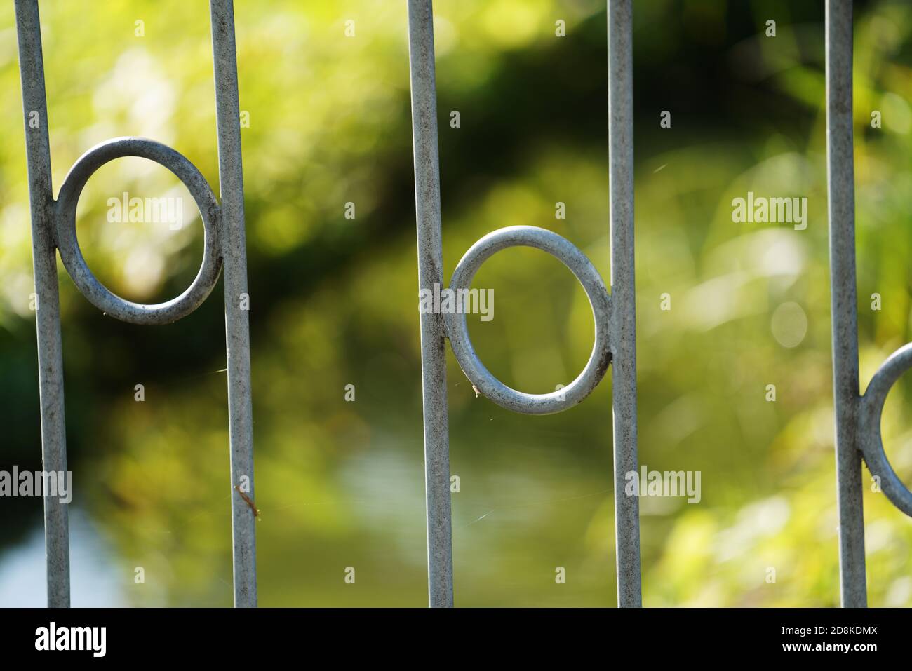 Closeup shot of a metal fence with circles in the middle of the lines ...
