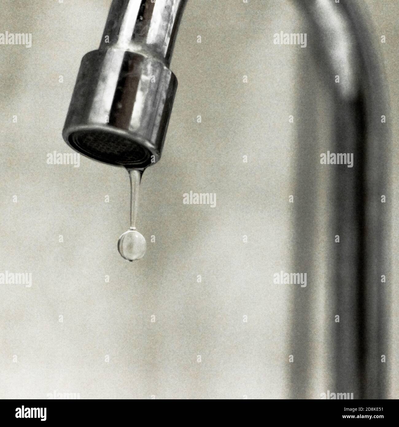 Dripping tap. The water droplet translated to Portuguese is 'A gota d'água' also is an idiomatic expression equivalent to 'The last straw'. Stock Photo