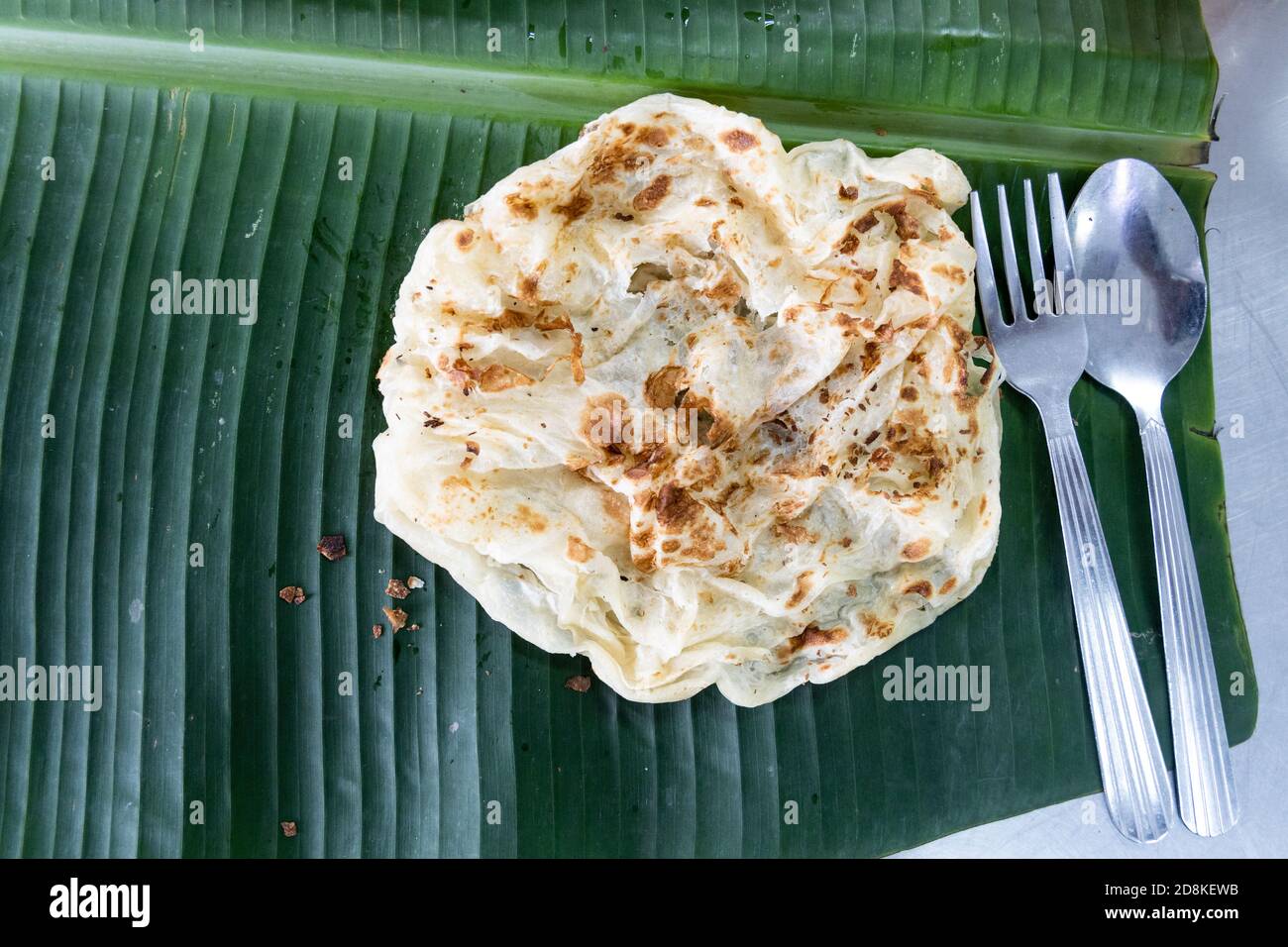 Roti canai or paratha on banana leaf, favourite Malaysian food Stock Photo