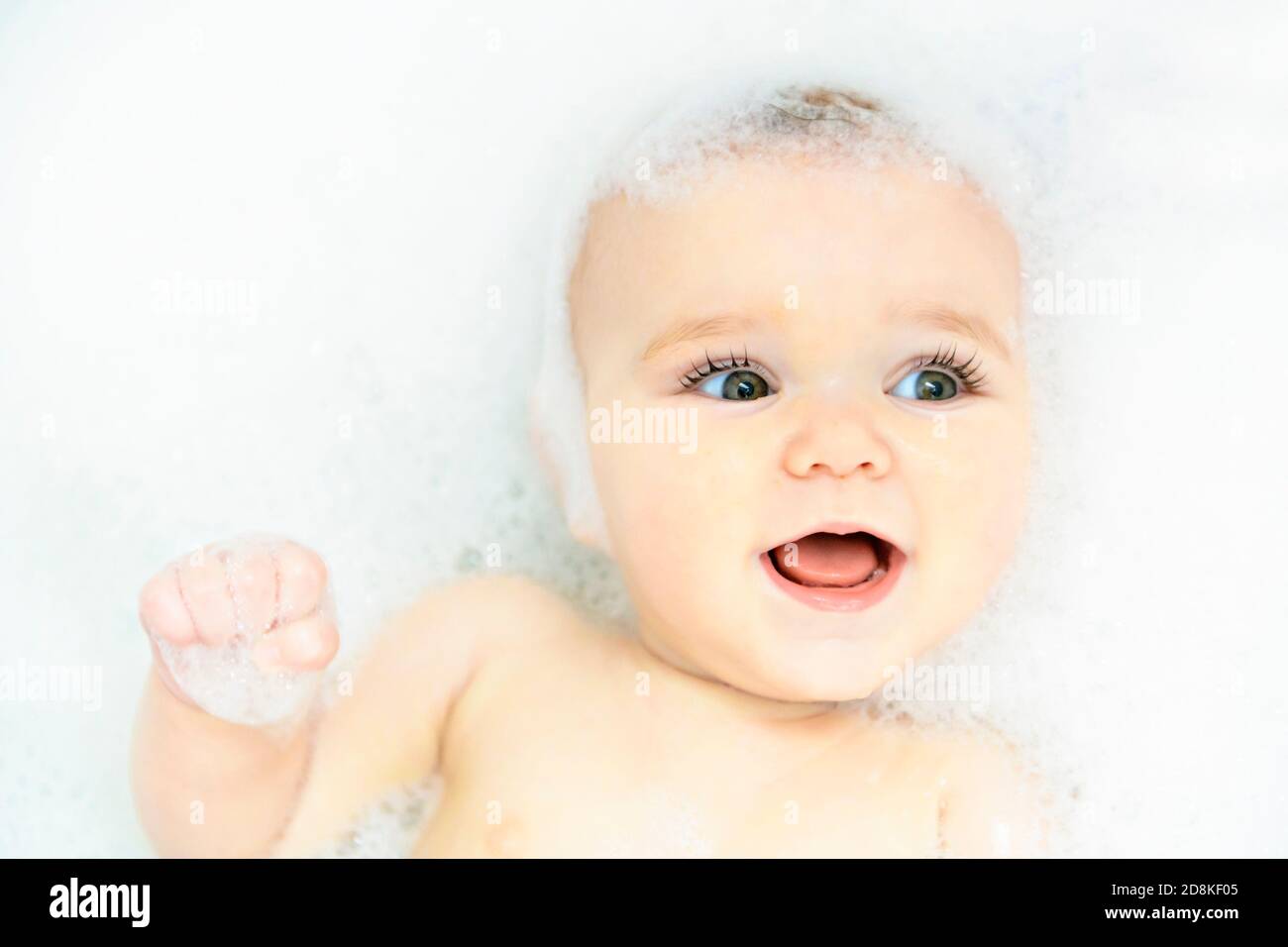 A Baby girl bathes in a bath with foam and soap bubbles Stock Photo Alamy