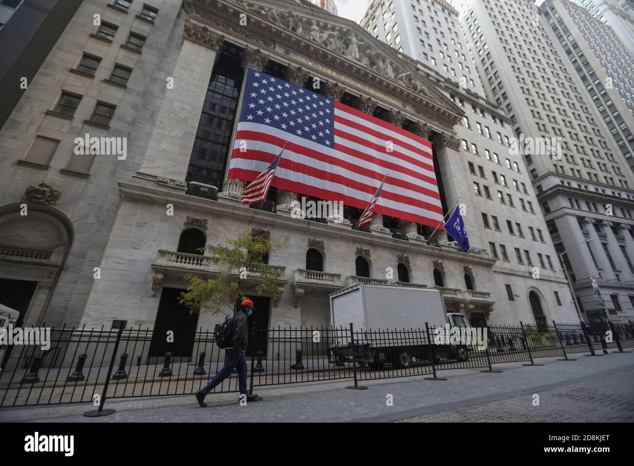 New York, USA. 30th Oct, 2020. A pedestrian walks past the New York Stock Exchange in New York, the United States, Oct. 30, 2020. U.S. stocks closed lower on Friday, as a pronounced slide in tech sector weighed on the market. The Dow Jones Industrial Average fell 157.51 points, or 0.59 percent, to 26,501.60. The S&P 500 was down 40.15 points, or 1.21 percent, to 3,269.96. The Nasdaq Composite Index shed 274.00 points, or 2.45 percent, to 10,911.59. Credit: Wang Ying/Xinhua/Alamy Live News Stock Photo
