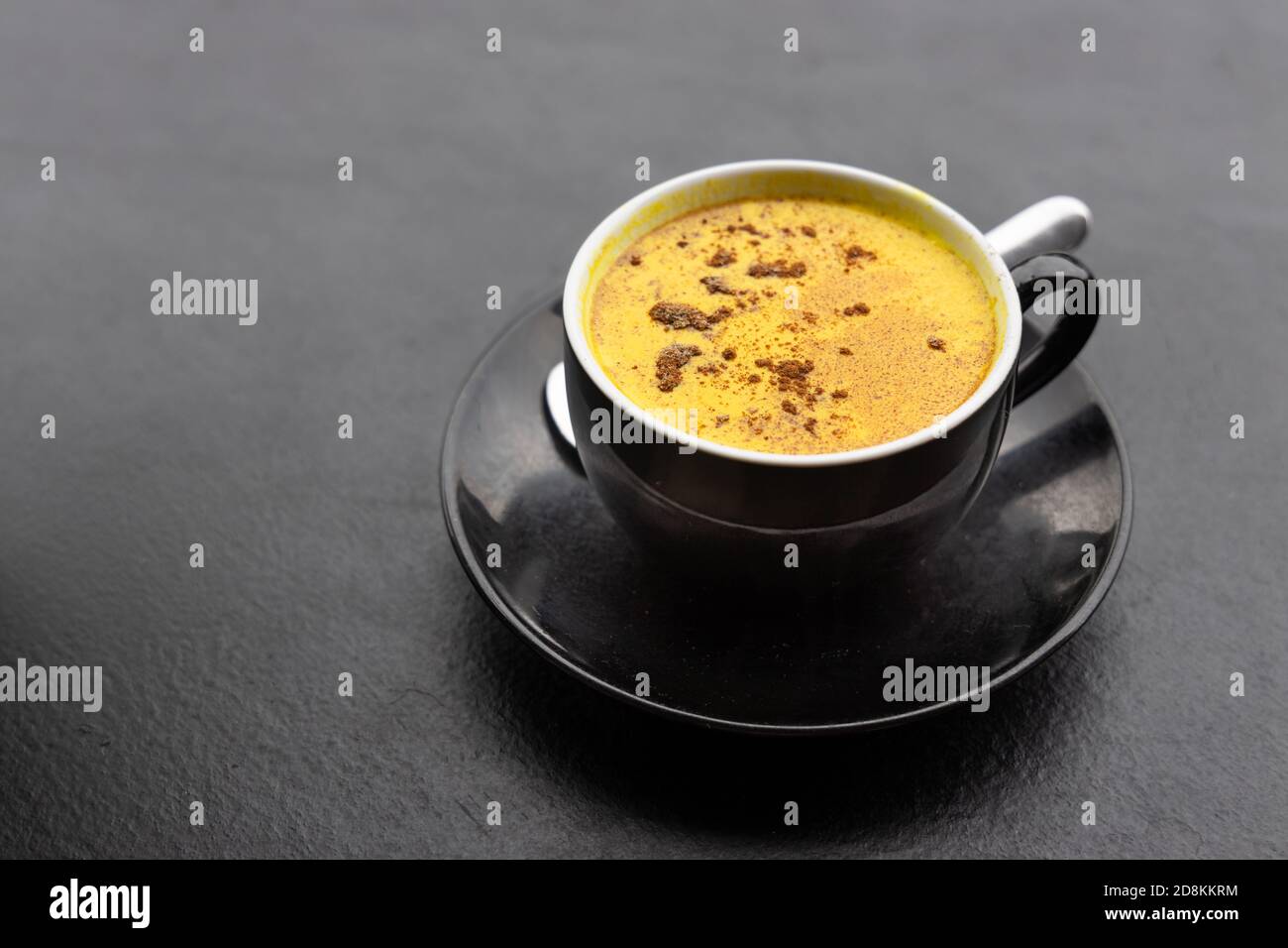 Serving of aromatic turmeric black coffee against dark table Stock