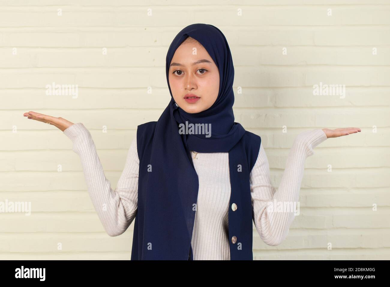 Young asianwoman wearing hijab smiling confident pointing with fingers to different directions. Stock Photo