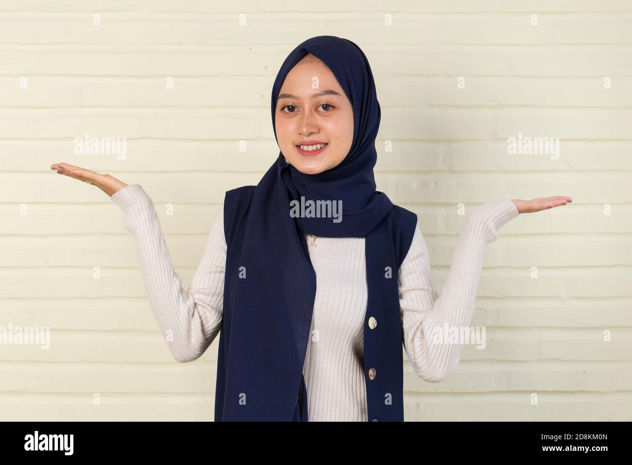 Young asianwoman wearing hijab smiling confident pointing with fingers to different directions. Stock Photo