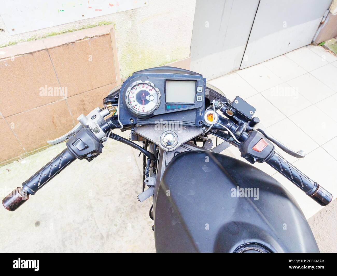 Black motorcycle steering wheel with round speedometer and screen Stock Photo