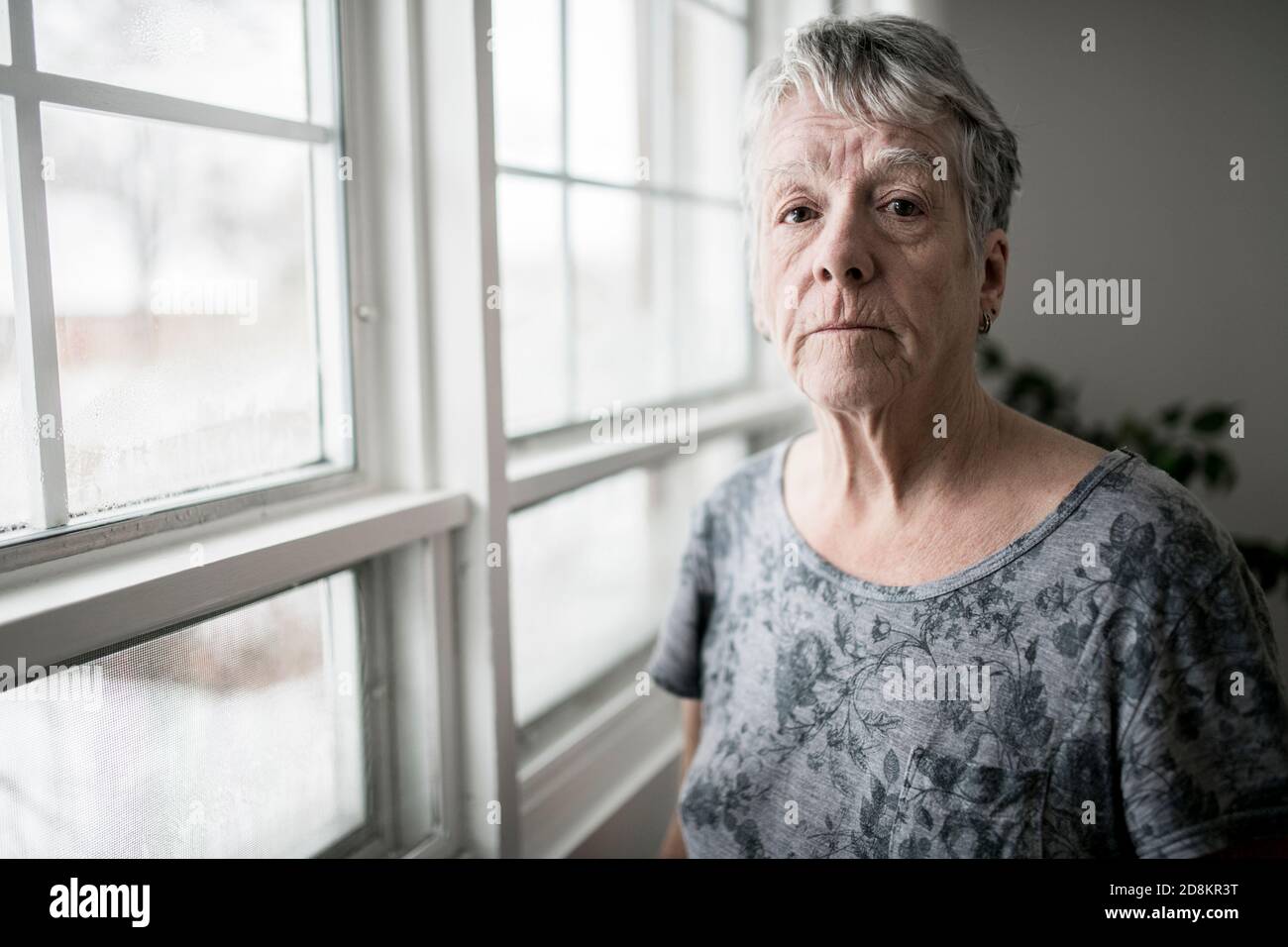 A sad lonely 70 years old senior in is apartment Stock Photo
