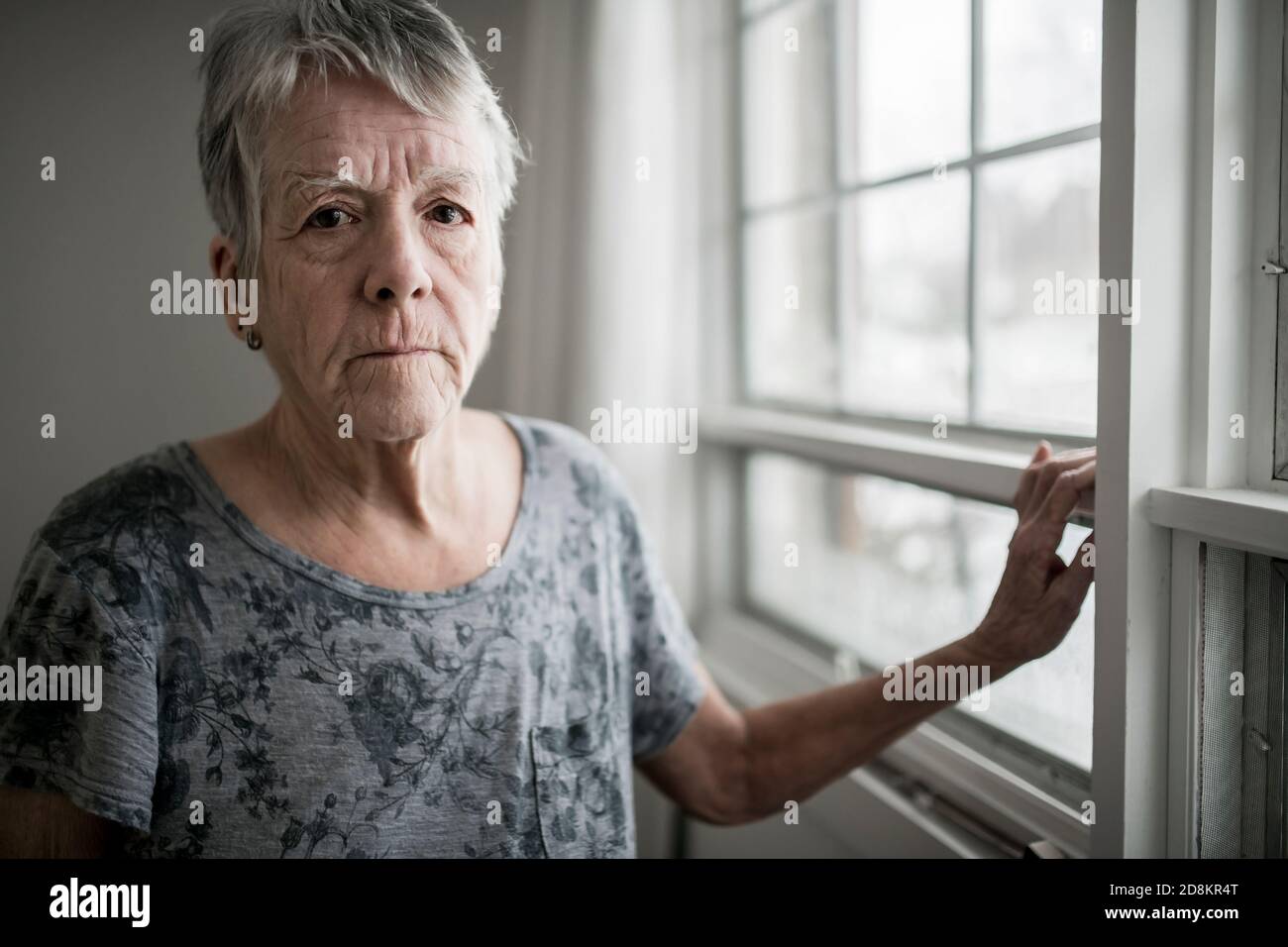 A sad lonely 70 years old senior in is apartment Stock Photo
