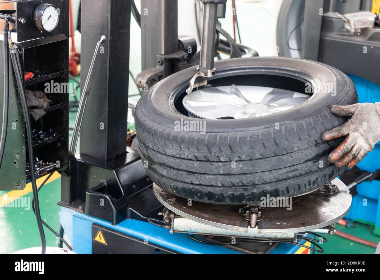 Series of worker removing tire from rim with removal machinery Stock