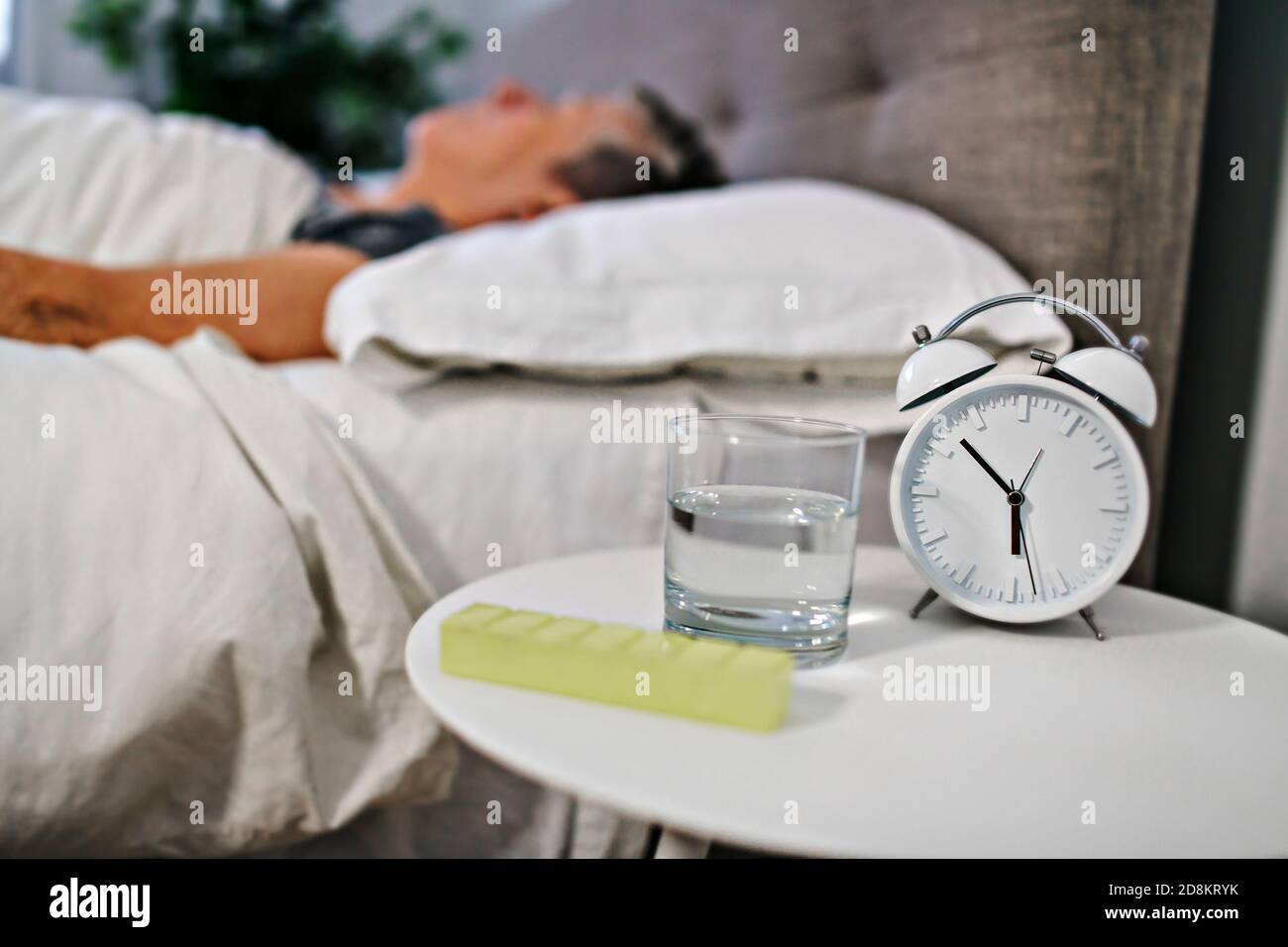 Unhealthy mature woman lying in bed, taking medicine from cold or