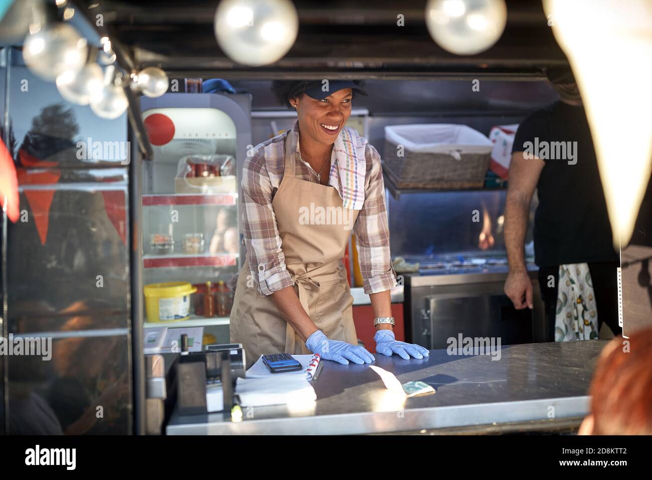 young friendly afro-american female employee in street fast food service, food truck concet Stock Photo