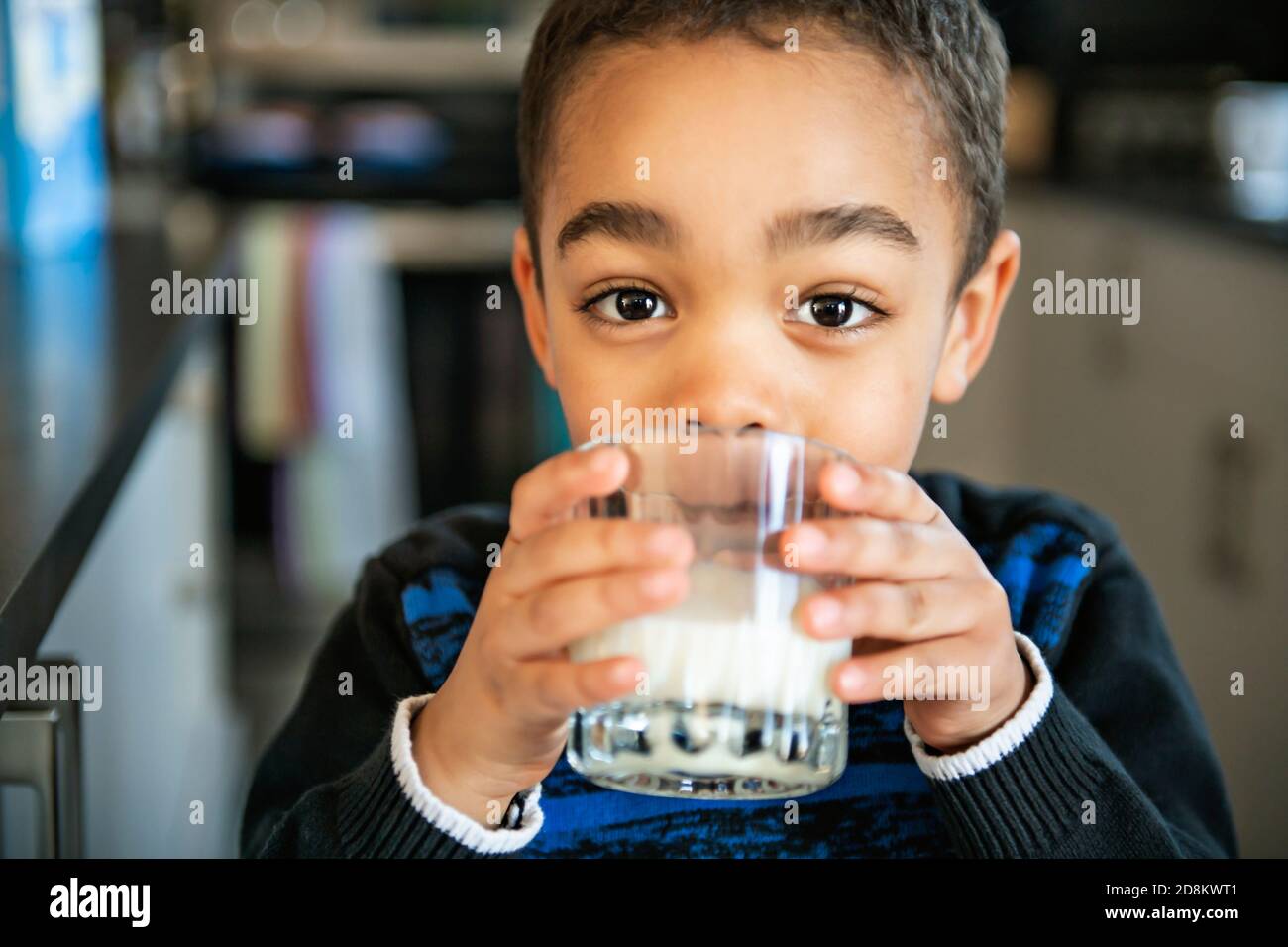 Cute African American boy drinking milk at home Stock Photo