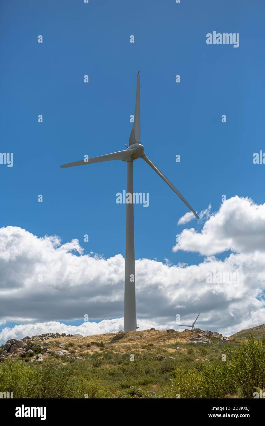 View of a wind turbine on top of mountains, cloudy sky as background ...