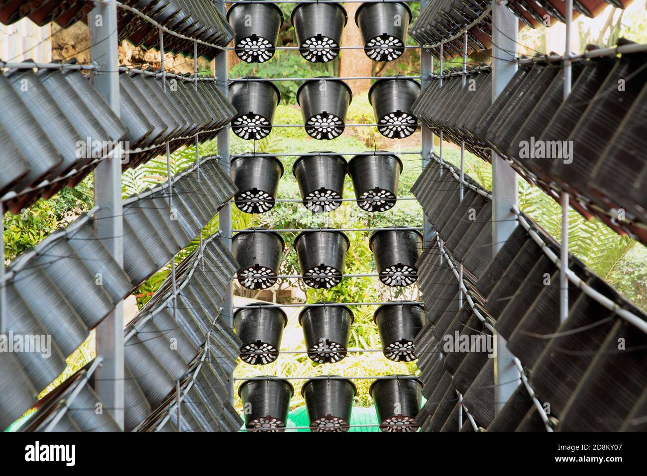 The background of old plant plastic pot hanging on metal fence at garden. Stock Photo
