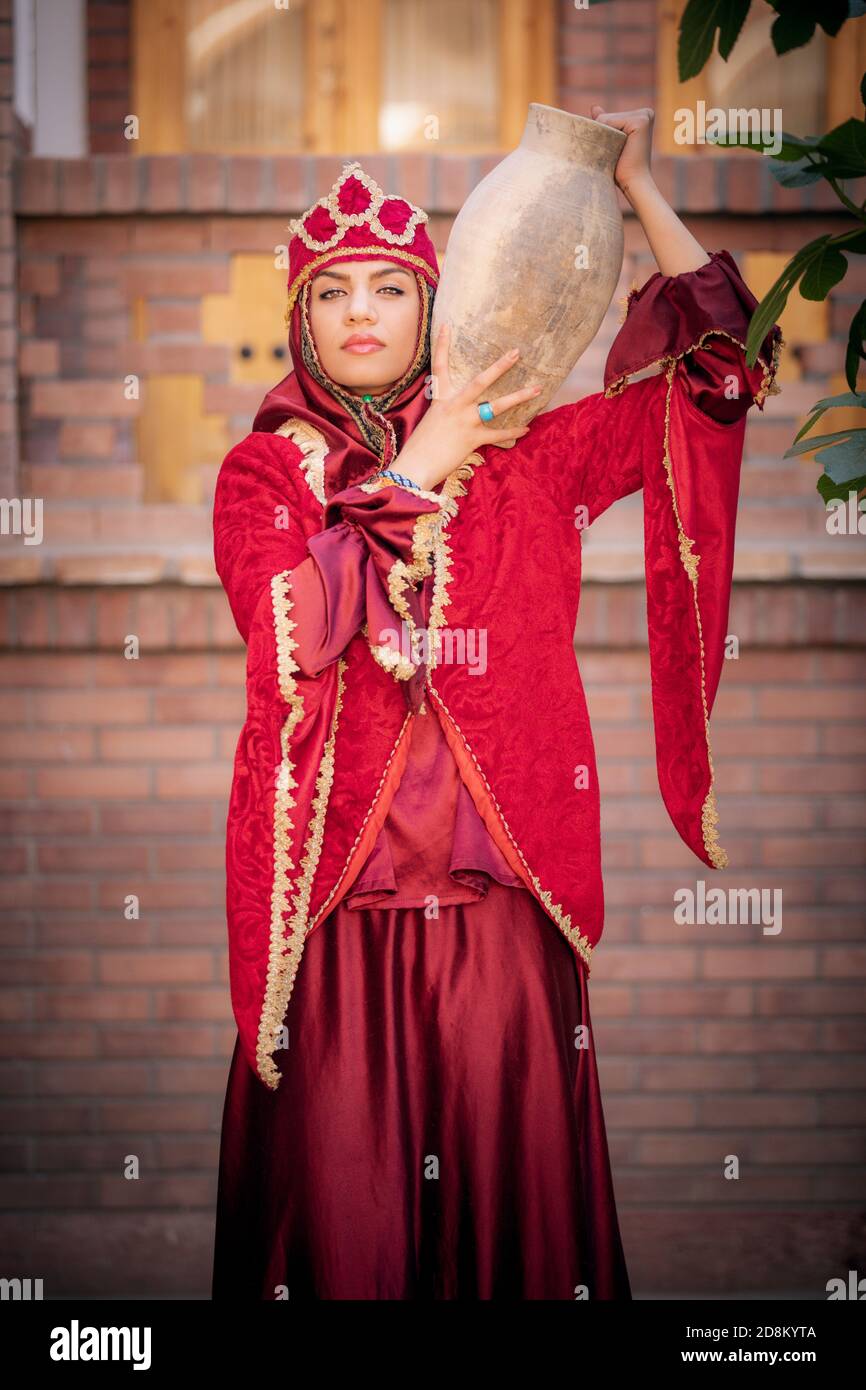 young beautiful Iranian lady in traditional clothing with a ceramic water dish Stock Photo