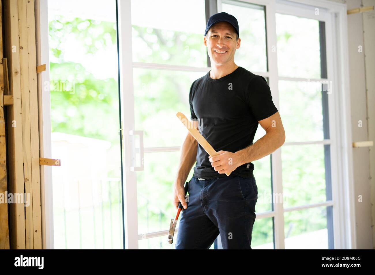 A handsome young man installing Double Sliding Patio Door in a new