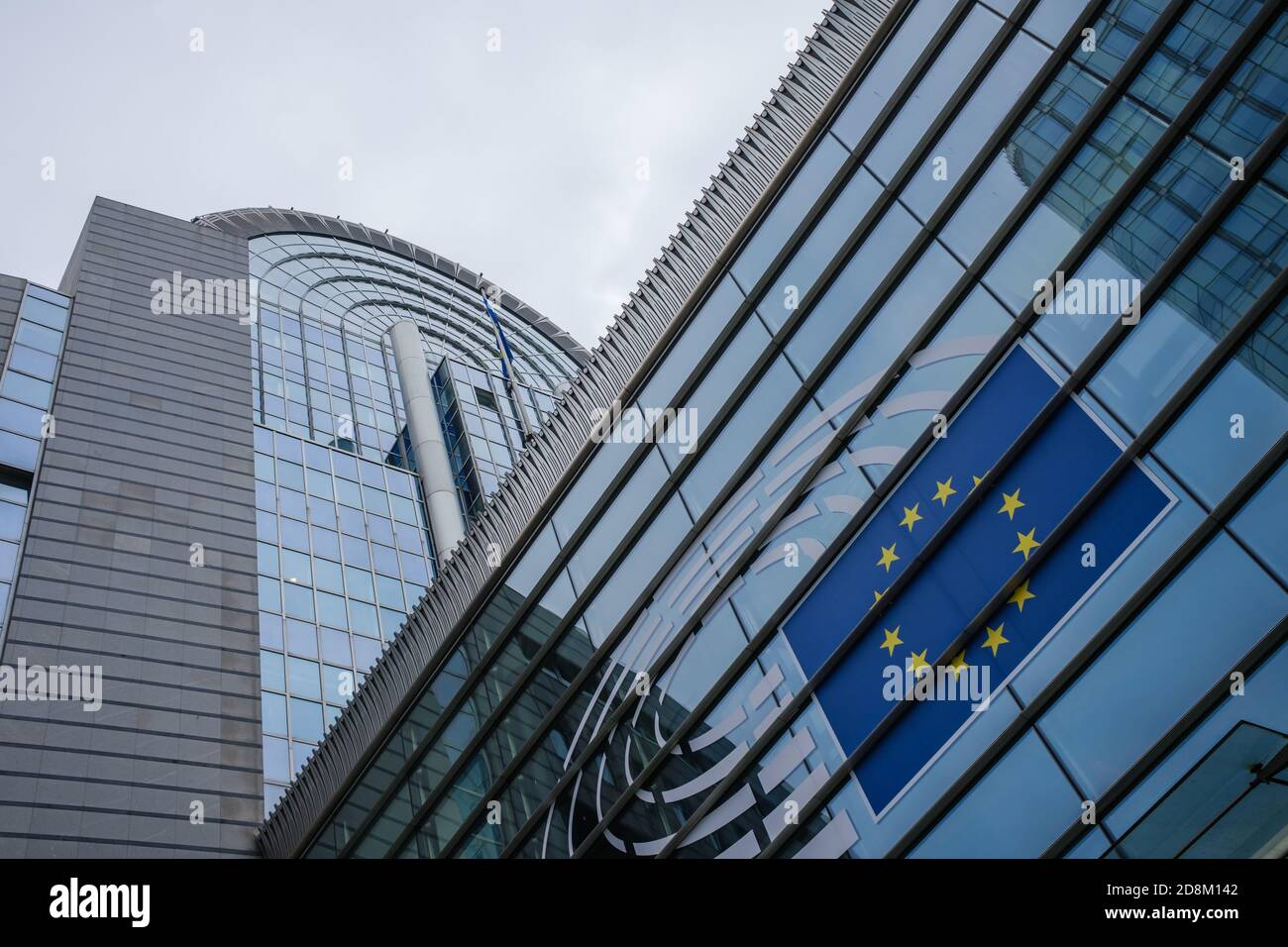 BRUSSELS, BELGIUM - Oct 21, 2020: Detail of the European parliament building, focus on the EU flag. Photo taken on a cloudy day Stock Photo
