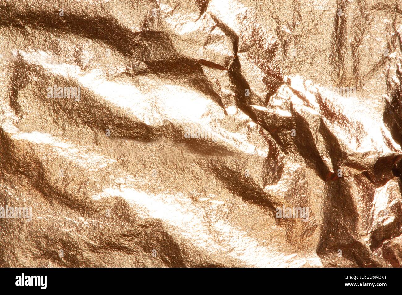 Gold bright shiny real texture of a crumpled sheet. Stock Photo