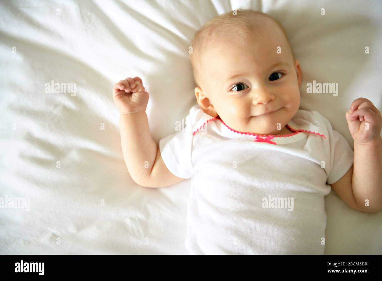 Cute happy baby girl in diaper on bed Stock Photo