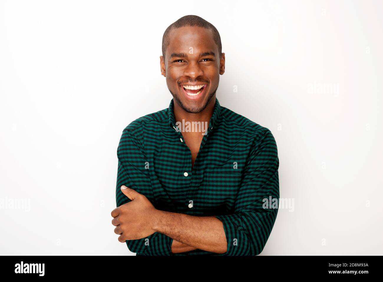 Portrait of happy young black guy smiling with arms crossed against ...