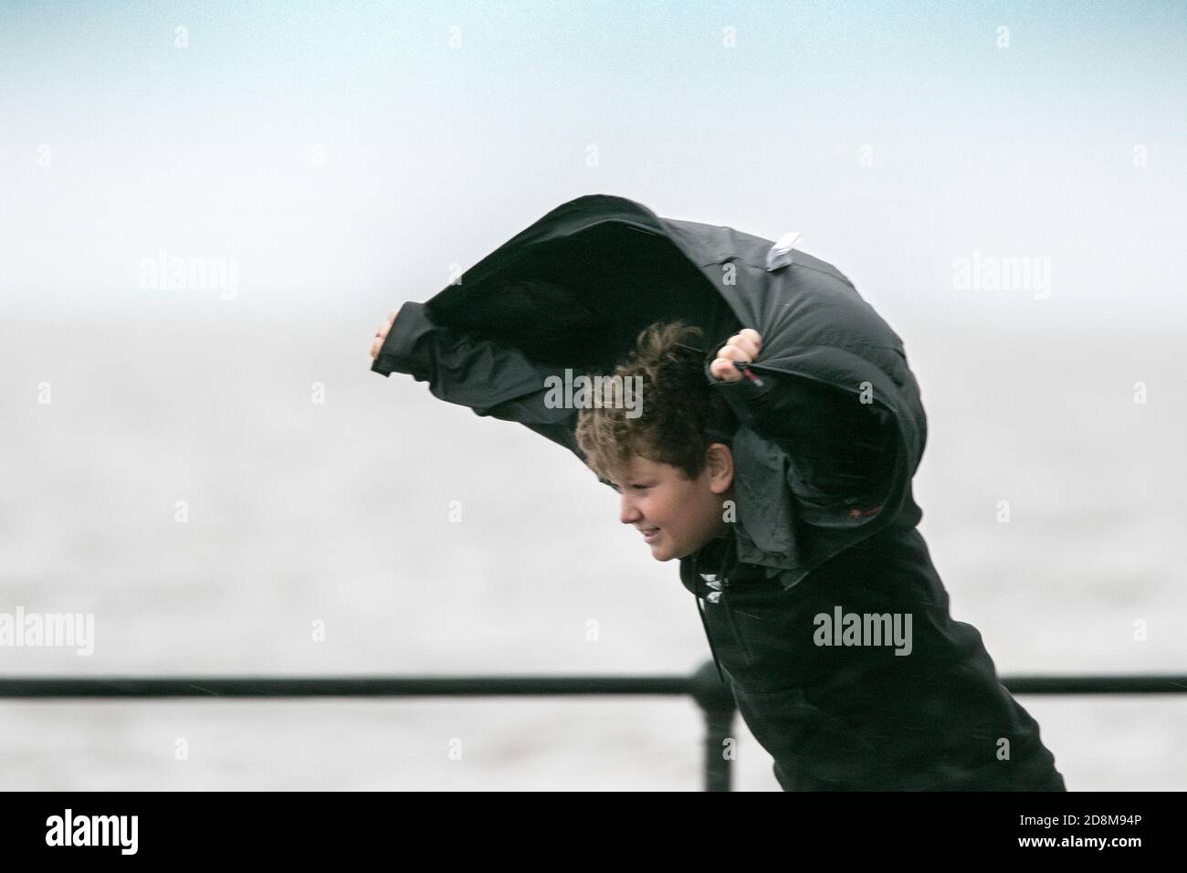 Crosby, Merseyside, 31 October 2020.  A young teenager has some fun catching the wind as storm force winds and high tide collide to batter the north west coastline at Crosby in Merseyside.   Credit: Cernan Elias/Alamy Live News Stock Photo