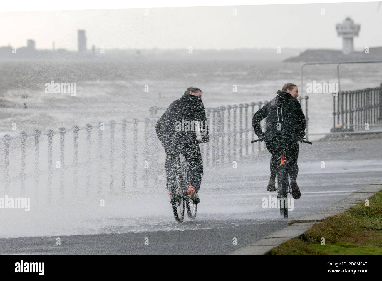 Crosby, Merseyside, 31 October 2020.  A brave cyclist ridea along the promenade as storm force winds and high tide collide to batter the north west coastline at Crosby in Merseyside.   Credit: Cernan Elias/Alamy Live News Stock Photo