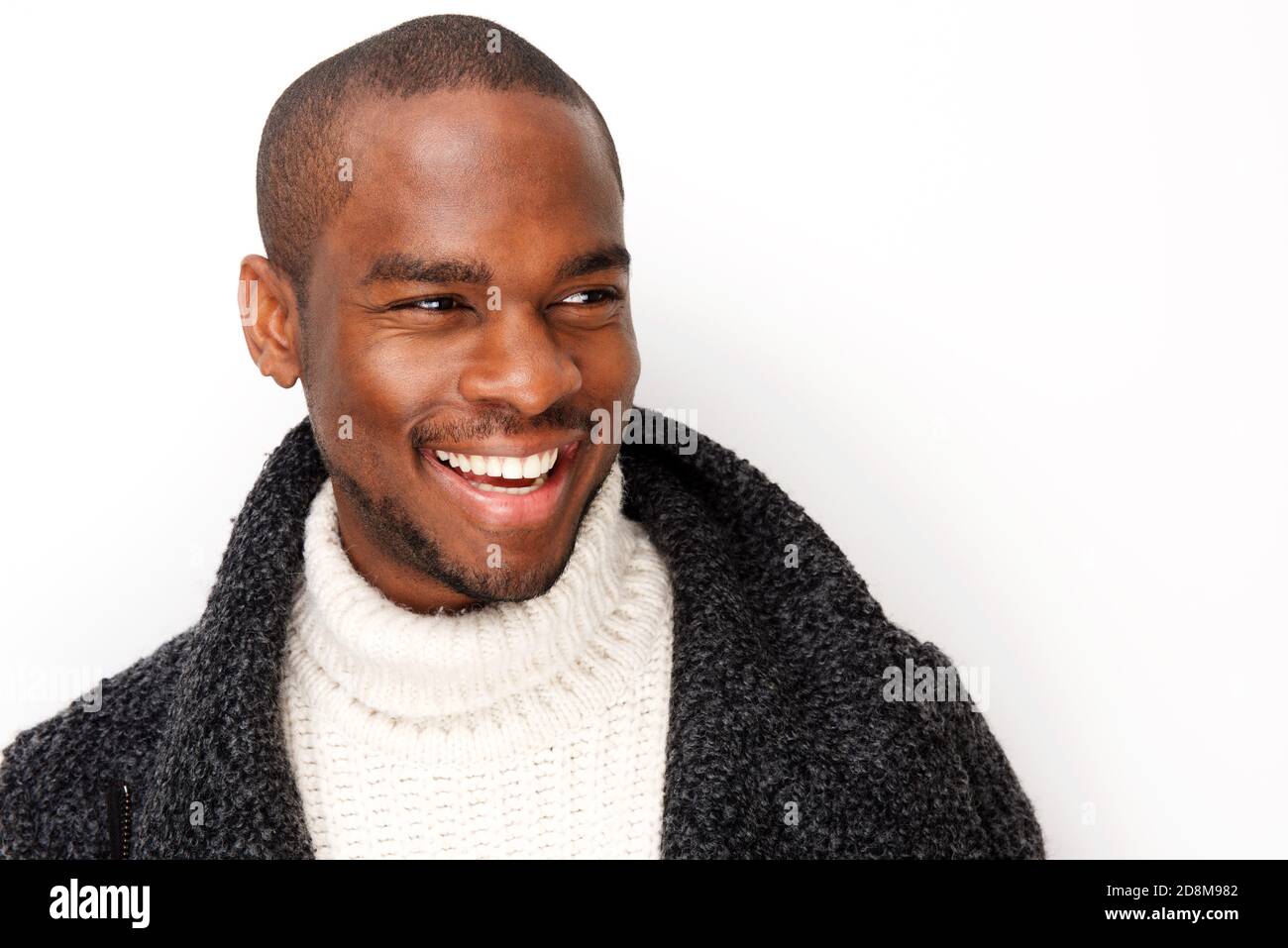 Close up portrait of handsome young black man smiling with coat by ...