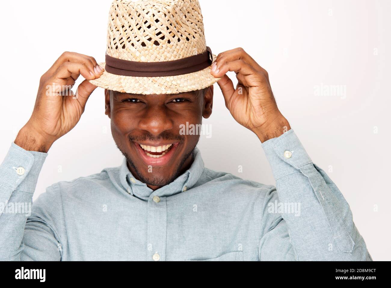 Close up portrait of handsome young black man smiling with hat against ...