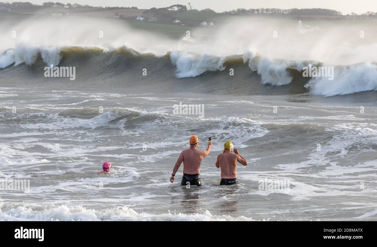 Myrtleville, Cork, Ireland. 31st October, 2020. Three swimmers watch a film the waves during Storm Aiden at Myrtleville, Co. Cork, Ireland.- Credit; David Creedon / Alamy Live News Stock Photo