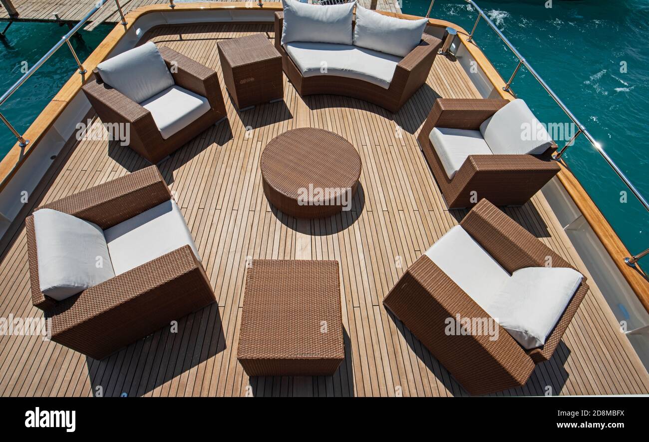 Rear teak deck of a large luxury motor yacht with chairs sofa and table