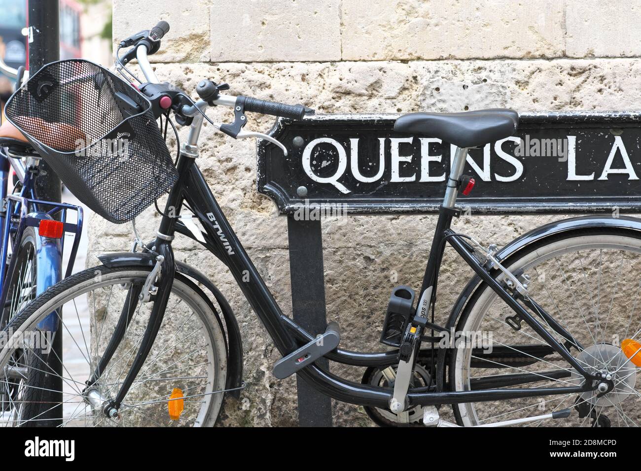 Oxford Oxfordshire UK - bicycles locked to a Queens Lane road sign in the University area of the city Stock Photo