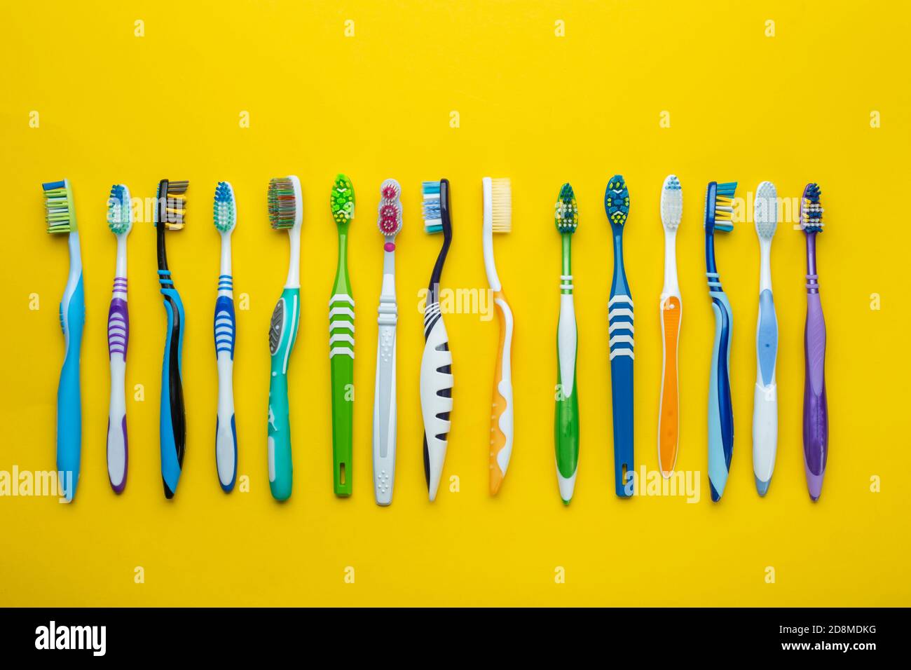 Toothbrushes on yellow background. Hygiene of the oral cavity. Top view ...