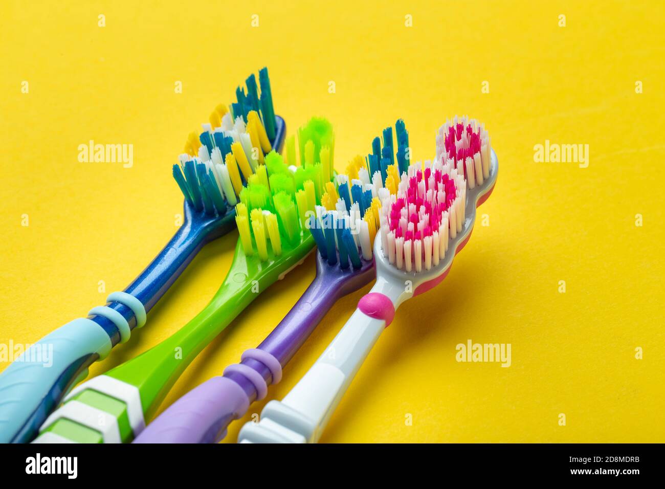Toothbrushes on yellow background. Hygiene of the oral cavity. Top view ...