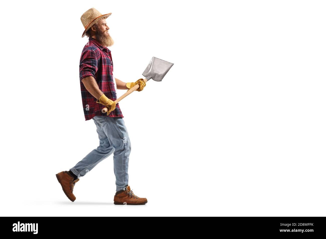 Full length profile shot of a bearded farmer walking with a shovel ...