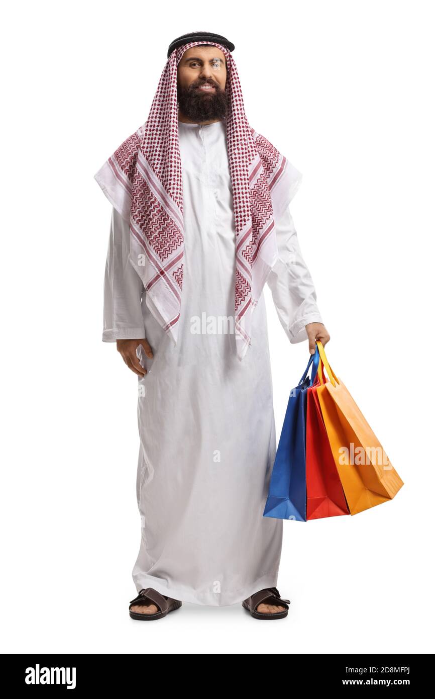 Full length portrait of an arab man in a thobe holding shopping bags isolated on white background Stock Photo