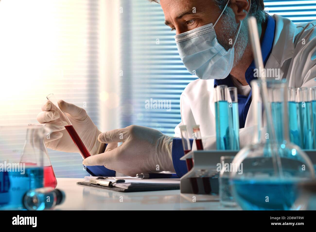 Medical laboratory technician analyzing blood samples in testing room