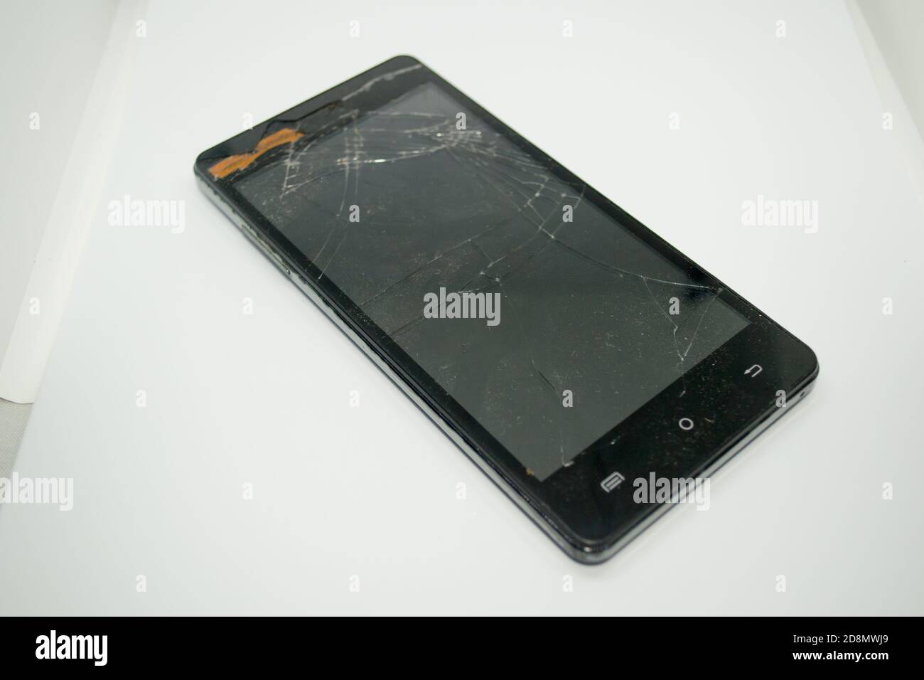 A color black mobile smartphone with a crashed/cracked or broken screen isolated in white background Stock Photo